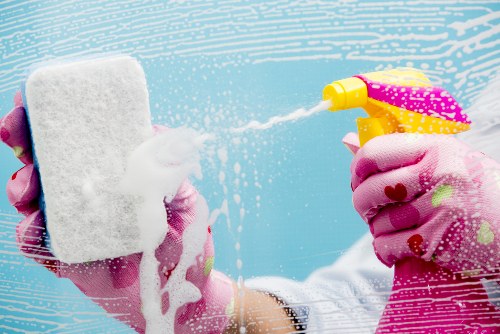 Experienced cleaner dusting and vacuuming a bright Belsizepark bedroom